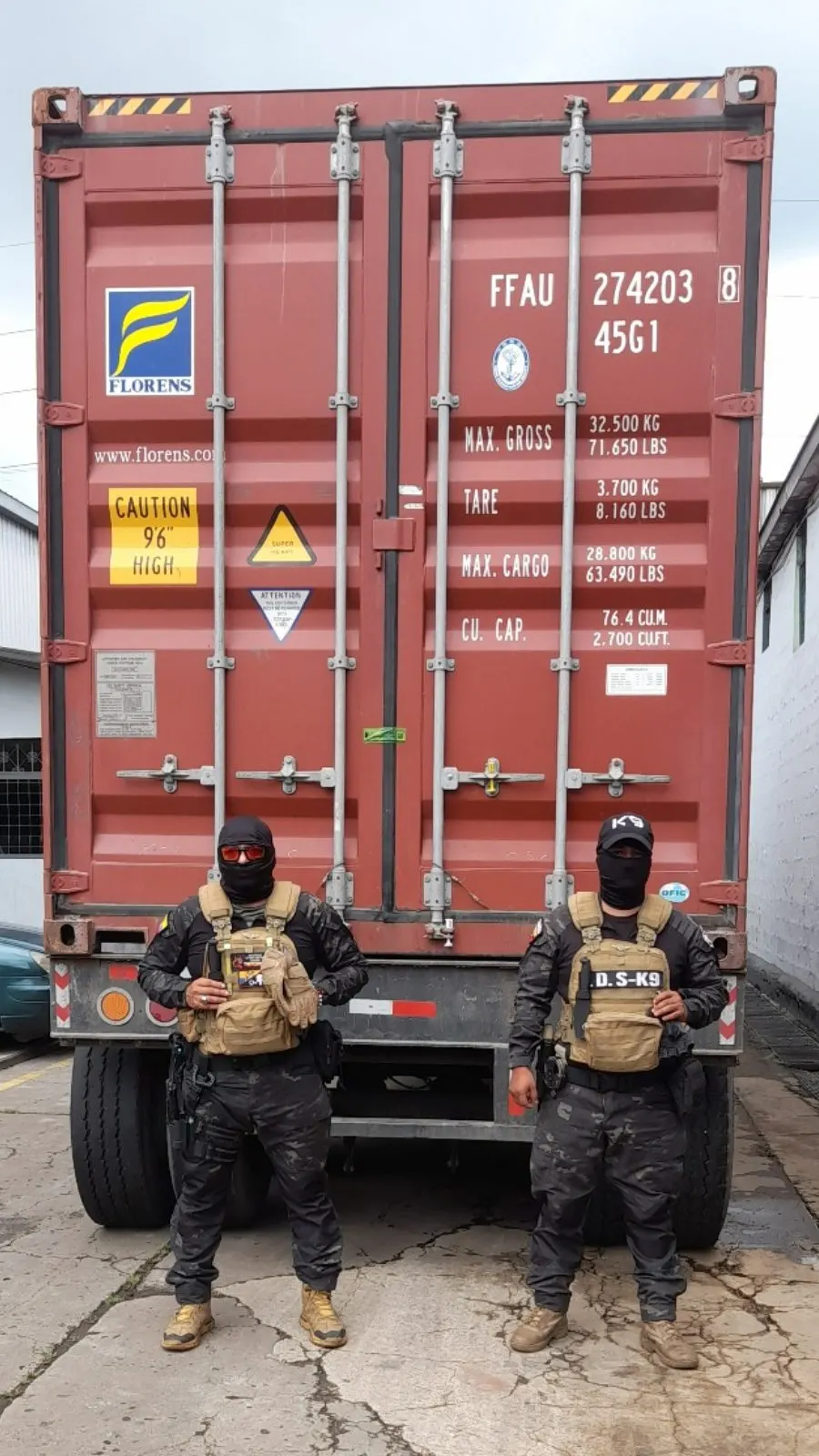 Dos guías K9 frente a un contenedor refrigerado